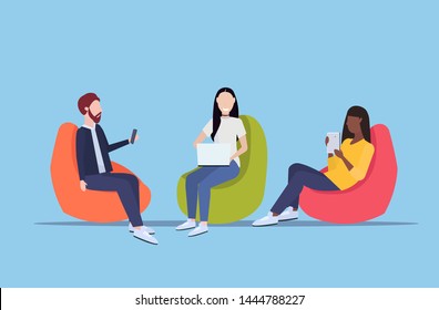 businesspeople sitting in bean bag armchair mix race colleagues team using digital gadgets social media communication concept flat full length horizontal