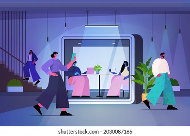 businesspeople working in protective glass cabins in modern dark night office horizontal