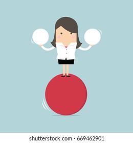 Businesswoman balancing on red ball holding two spheres.