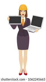 Businesswoman in construction helmet holding a laptop notebook and digital tablet PC. Full length portrait of businesswoman in a flat style. Vector illustration.