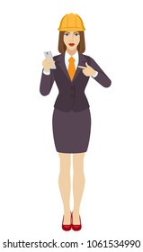 Businesswoman in construction helmet pointing at a mobile phone. Full length portrait of businesswoman in a flat style. Vector illustration.