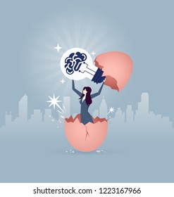 Businesswoman Holding A Big Idea Light Bulb And Breaking Out Of A Giant Egg Shell