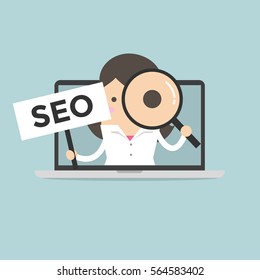 Businesswoman holding SEO sign and looking through a magnifying glass in computer notebook