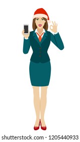 Businesswoman in Santa hat holding a mobile phone and showing a okay hand sign. Full length portrait of businesswoman in a flat style. Vector illustration.
