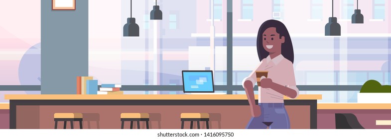 businesswoman sitting on chair at bar counter with laptop coffee break concept african american business woman drinking cappuccino modern cafe interior flat portrait horizontal