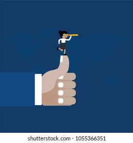 Businesswoman with spyglass on a thumbs up hand with blue background