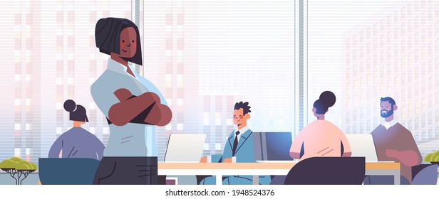 businesswoman standing in front of mix race businesspeople coworkers discussing during conference meeting