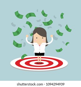 Businesswoman standing on a big target and the money flow in the air.