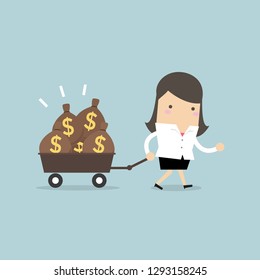 Businesswoman walking with a trolley full of money bags.