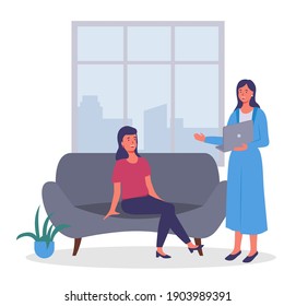 Businesswomen dressed in formal clothes sitting on the sofa, standing with computer in room and talking. Office meeting and consideration of working affairs. Office workers women in workspace