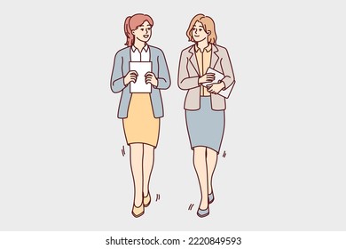 Businesswomen walking together talking discussing business ideas. Female employees with documents or paperwork in hands walk chatting. Vector illustration. 