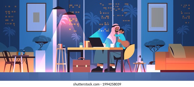 busy arab father freelancer with little son looking in laptop screen freelance fatherhood concept