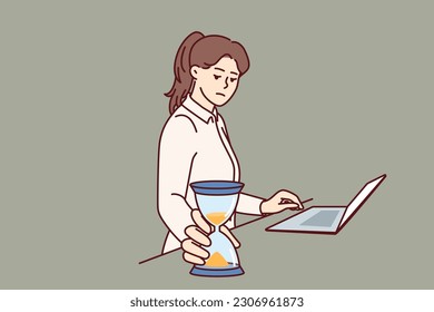 Busy businesswoman with hourglass keeps track of time until deadline so as not to violate terms of important contract. Freelancer girl in business suit stands near laptop and does time management