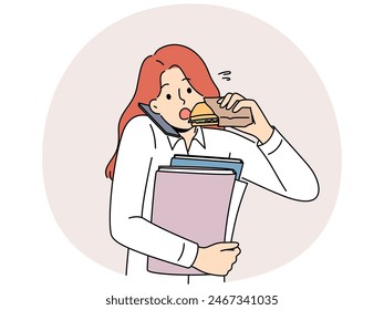 Busy multitasking woman answers phone biting on sandwich to save time at lunch. Young businesswoman with folders in hands eats and works in multitasking mode, wishing to succeed in career