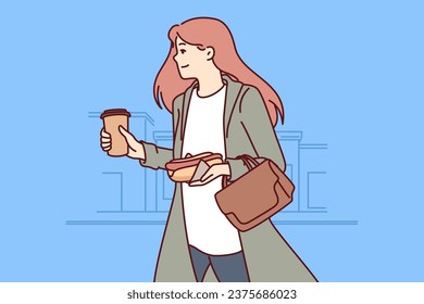 Busy successful woman hurries to work, runs through city streets with hot dog and coffee in hands. Busy positive businesswoman doesnt have time to have breakfast in morning and eats on go