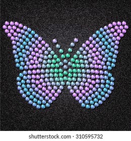 Butterfly built of translucent gems on a background of black and gray fabric.