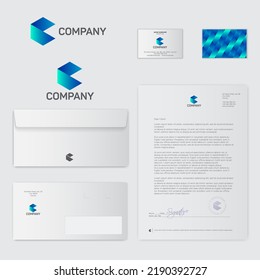 C monogram like origami figure. Letter C consist of blue ribbon with letters. Corporate documents: pen, blank of letter, envelope, post card, business card.