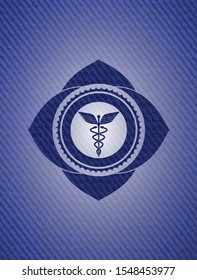 Caduceus medical icon inside emblem with denim high quality background