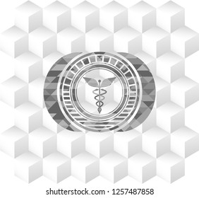Caduceus medical icon inside grey badge with geometric cube white background