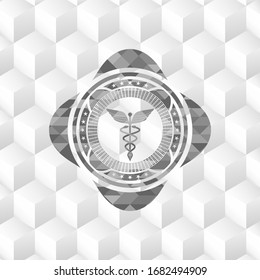 Caduceus medical icon inside grey badge with geometric cube white background