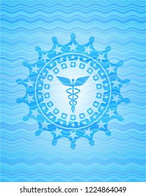 Caduceus medical icon inside light blue water badge.