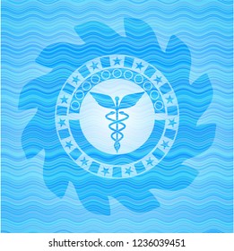 Caduceus medical icon inside light blue water wave style emblem.