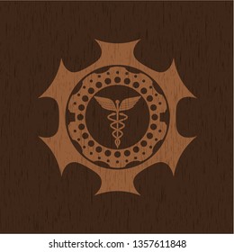 Caduceus medical icon inside wooden emblem. Vintage.