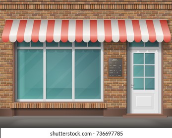 Cafe or store front with large transparent window and awning. Facade of red brick. Empty glass showcase of boutique. Entrance in the small  shop.