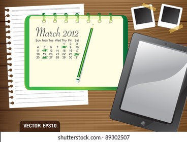 Calendar 2012 March on paper green Notebook.  With Fictitious touch tablet PC and photo frame. on brown wood background. Vector template for design work
