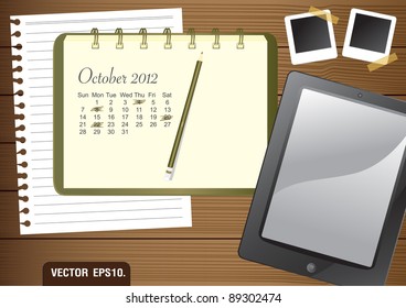 Calendar 2012 October on paper green Notebook.  With Fictitious touch tablet PC and photo frame. on brown wood background. Vector template for design work
