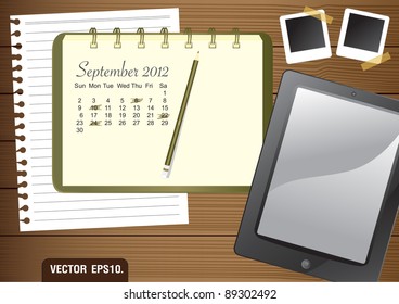 Calendar 2012 September on paper green Notebook.  With Fictitious touch tablet PC and photo frame. on brown wood background. Vector template for design work