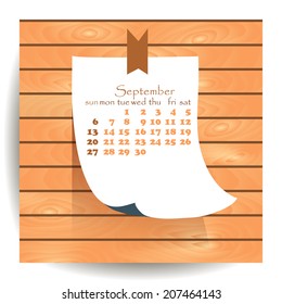 Calendar 2015 September: label sheet of paper on the wooden textured background.