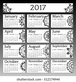 Calendar 2017 is decorated with mandalas. Black-and-white style, the beginning of the week from Sunday. Year calendar. Black background and black months. Gradient background.