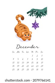 Calendar 2022. Month December. A cute tiger cub plays with a Christmas tree toy star. Merry Christmas. Symbol of Chinese New Year 2022. For calendar, planner, note