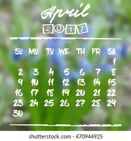Calendar design grid in hand written style with white lettering and dates of spring month April 2017 on natural blurred background. Blurry blue snowdrops. Vector illustration