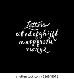 Calligraphic alphabet, font, black and white background. Letters written with a brush or chalk.