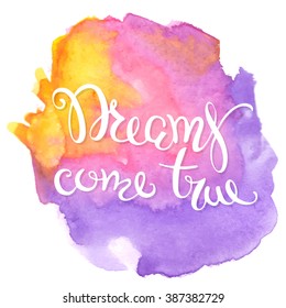 Calligraphic inscription DREAMS COME TRUE on watercolor background