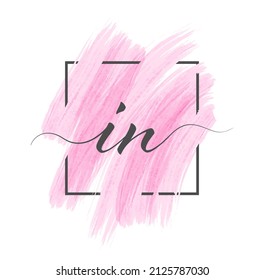 Calligraphic lowercase letters I and N are written in a solid line on a colored background in a frame.
