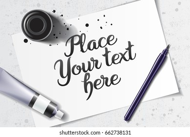 Calligraphy mockup with brush pen and black ink bottle on the background of white sheet of paper and grunge table