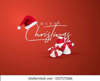 Calligraphy text Merry Christmas with santa hat and gift boxes on orange background can be used as greeting card design.