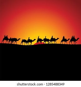 Camel caravan going through the desert in the sunset