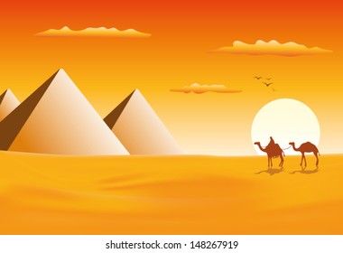 Camel caravan at pyramids in sunset