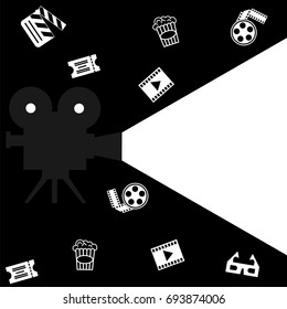 A camera with a beam of light on a black background with a ticket, a popcorn, 3d glasses, a film. 