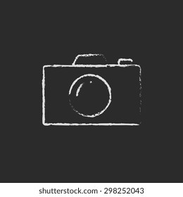 Camera hand drawn in chalk on a blackboard vector white icon on a black background