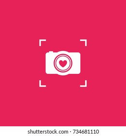Camera with heart shutter symbol, with viewfinder grid outside.