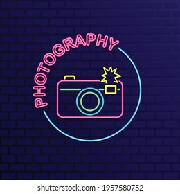 Camera neon sign on dark blue  brick wall
