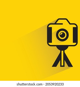 camera on tripod with shadow on yellow background