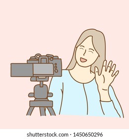 Camera recording a young female blogger talking while making a video
