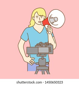 Camera recording a young female blogger talking while making a video