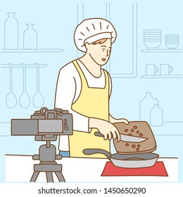 Camera recording a young male blogger cooking while making a video